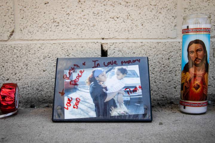Candles and a picture of a mother and daughter signed “Love, Dad” by the scene of ...