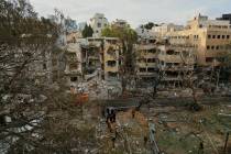 Rescue team work at the site where a missile launched from Iran struck Tel Aviv, Israel, Monday ...