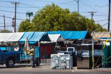 A vendor packs up an umbrella as merchandise is left unattended at the Broadacres Marketplace i ...