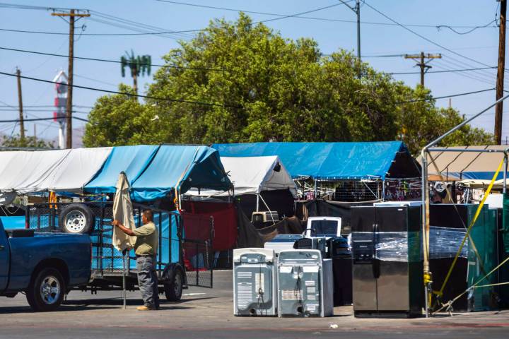 A vendor packs up an umbrella as merchandise is left unattended at the Broadacres Marketplace i ...